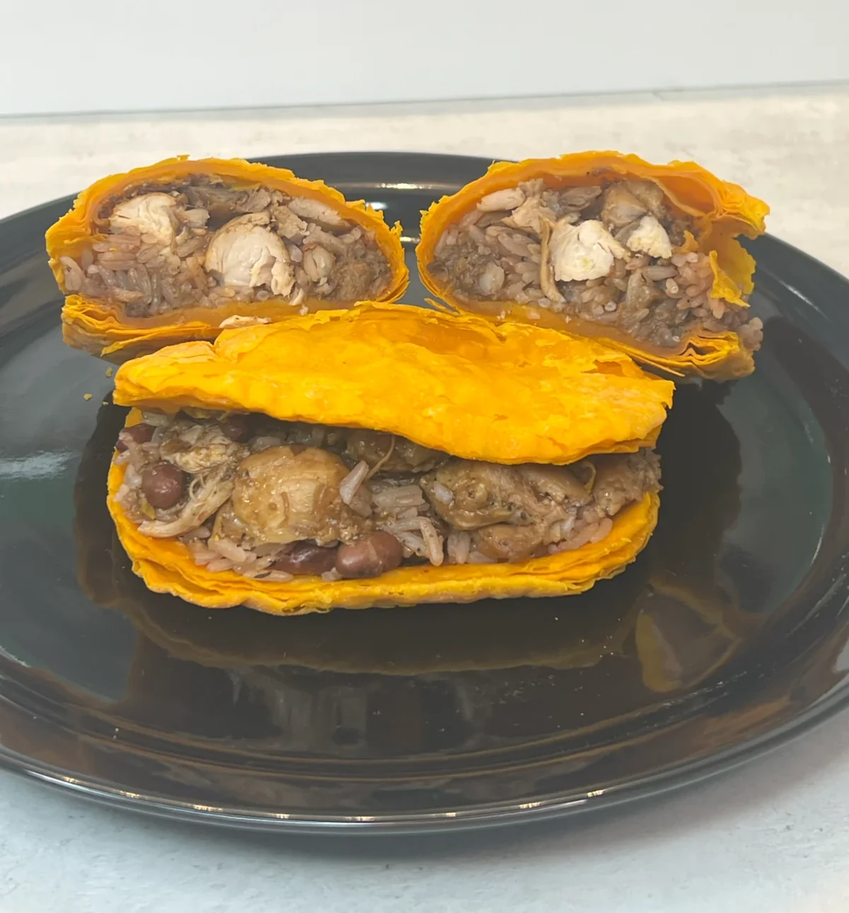 Sunday Dinner Patty, a Jamaican beef patty stuffed with rice and peas and brown stew chicken